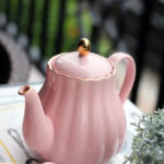 Englische Teekanne in Kürbisform aus Porzellan, rosa mit goldfarbenem Deckelknauf.