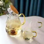Teekanne Glas Design mit zwei passenden Tassen auf einem Tisch.
