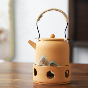 Japanische Teekanne mit Stövchen aus Keramik, verziert mit Bergmotiven.